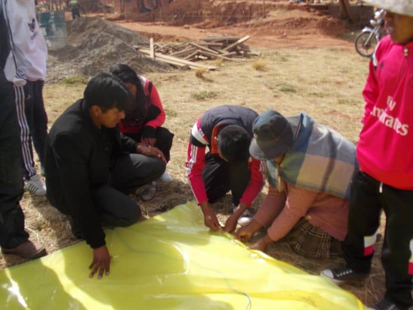 Costura de agrofilm para techado de la carpa solar del colegio, por parte de profesores, estudiantes y padres de familia 